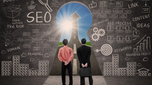 Business partners and SEO doodle on blackboard